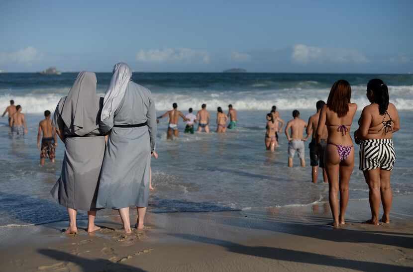  Two Polish nuns look at people bathing as hundreds of thousands of young Catholic pilgrims...