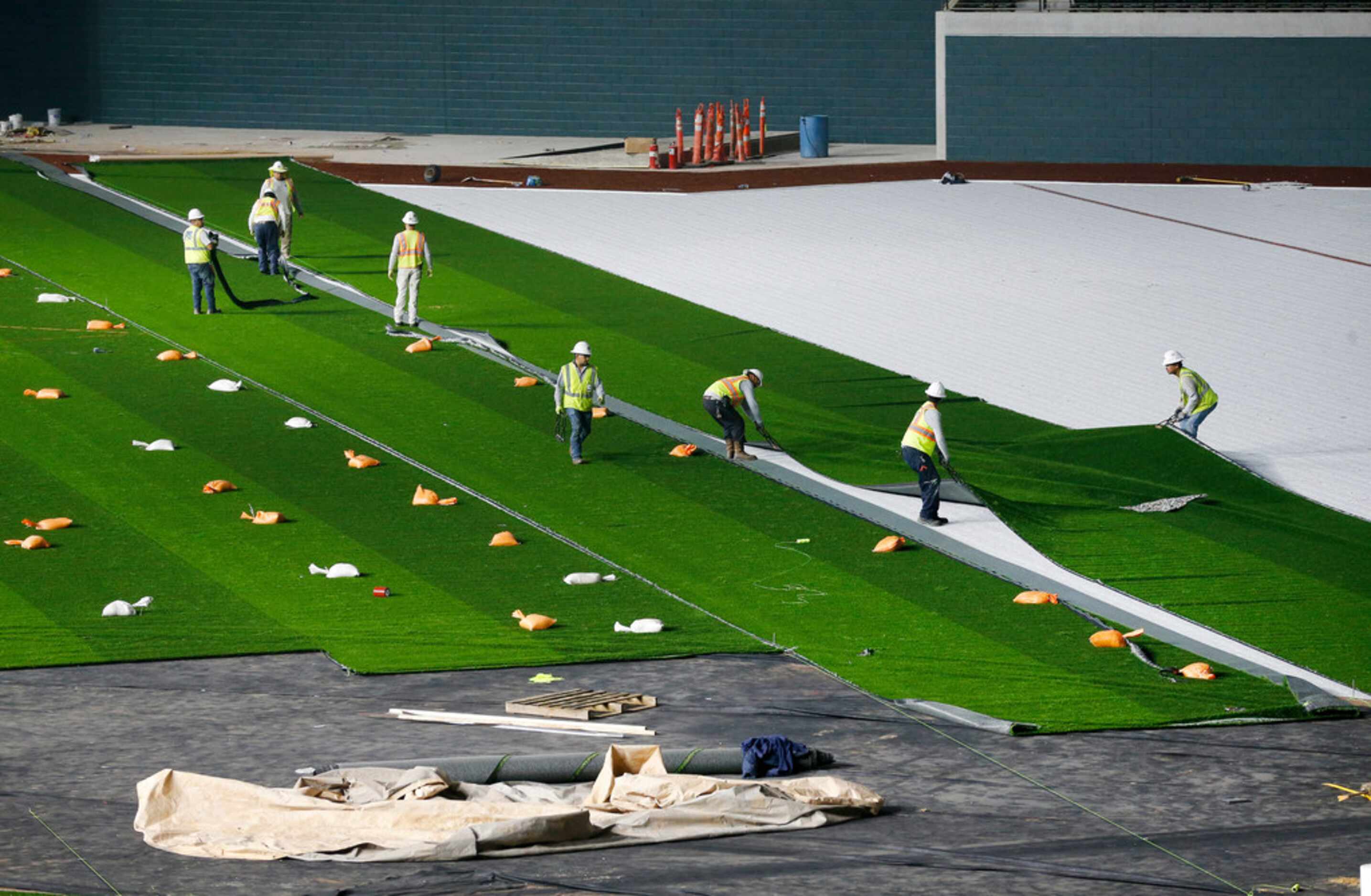 The synthetic grass by Shaw Sports Turf is being installed at Globe Life Field under...