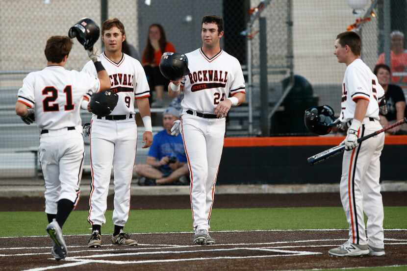 Rockwall's Zane Sloan (21) is congratulated by Justin Childers (9) and Will Frizzle (24) as...
