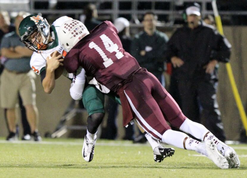 Garland Naaman Forest quarterback Justin Walker (9) laid out by Plano Senior High David...