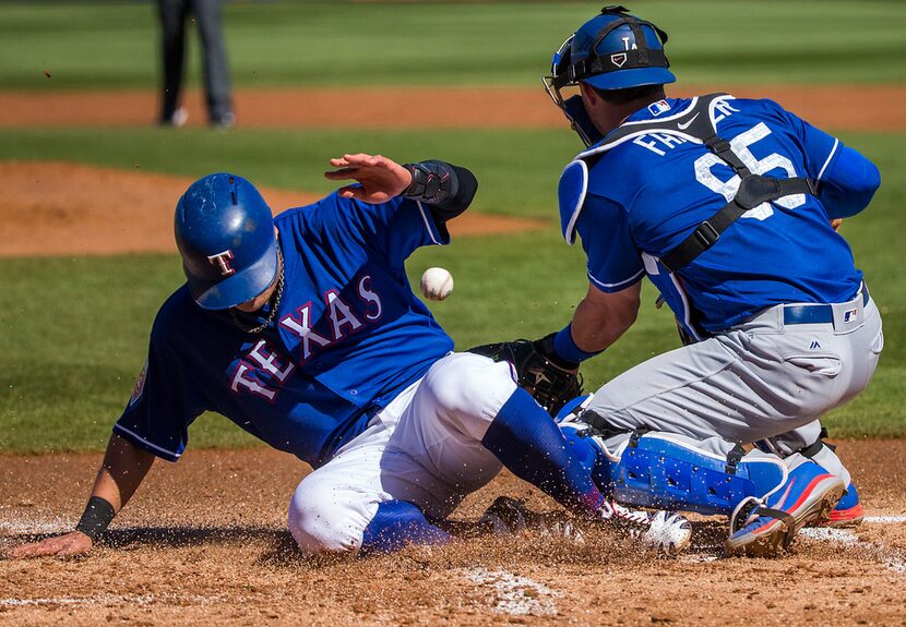 Texas Rangers designated hitter Shin-Soo Choo scores as the ball gets away from Los Angeles...