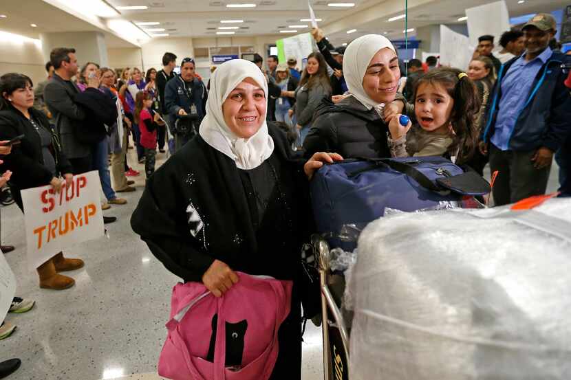 Najah Alshamieh (left) from Syria leaves Terminal D of DFW International Airport in Dallas...