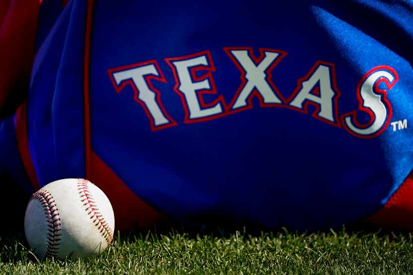 A baseball rests next to a player's bag during a Texas Rangers spring training workout at...