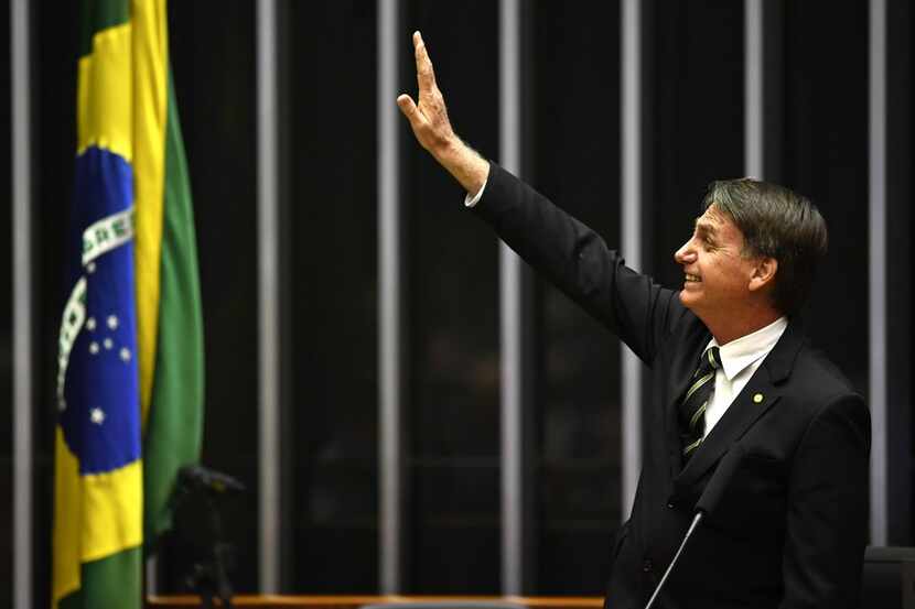 Far-right president-elect Jair Bolsonaro waves inside the Congress in Brasilia ahead of the...