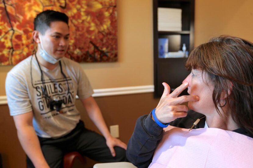 
Johnson (right) points out a tooth to Do that had been bothering her during the Smiles...