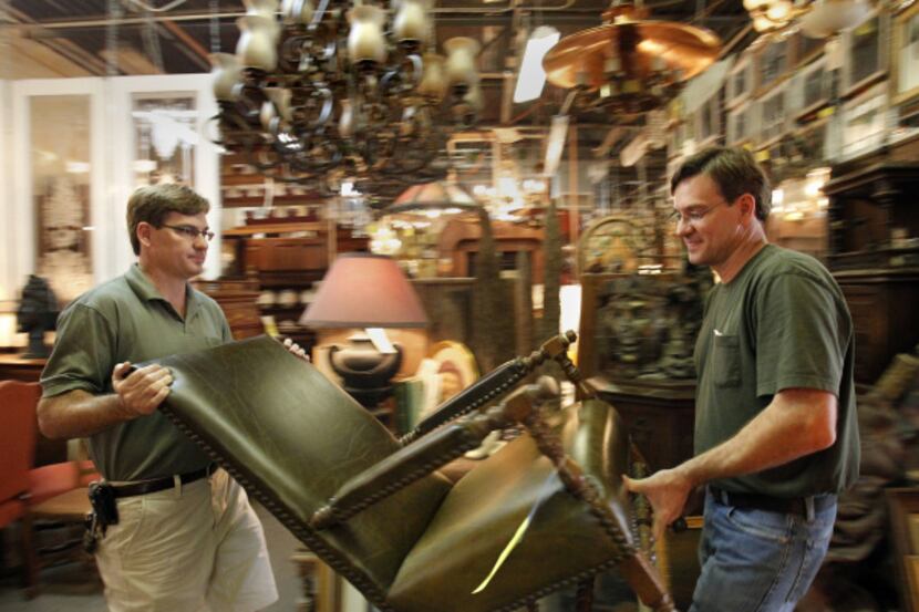Chris Paulsen (left) and brother Ted do the heavy lifting at their antiques store, Lots of...