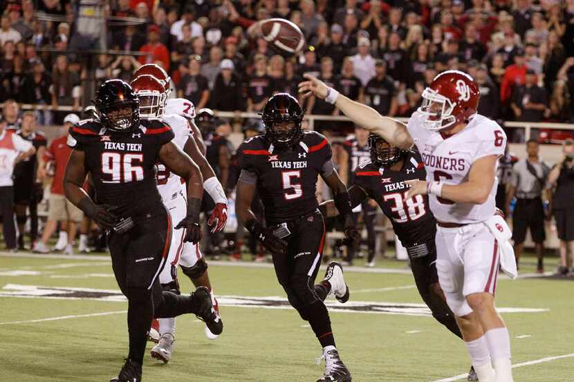Oklahoma's quarterback Baker Mayfield passes under heavy pursuit by Tech. Texas Tech in an...
