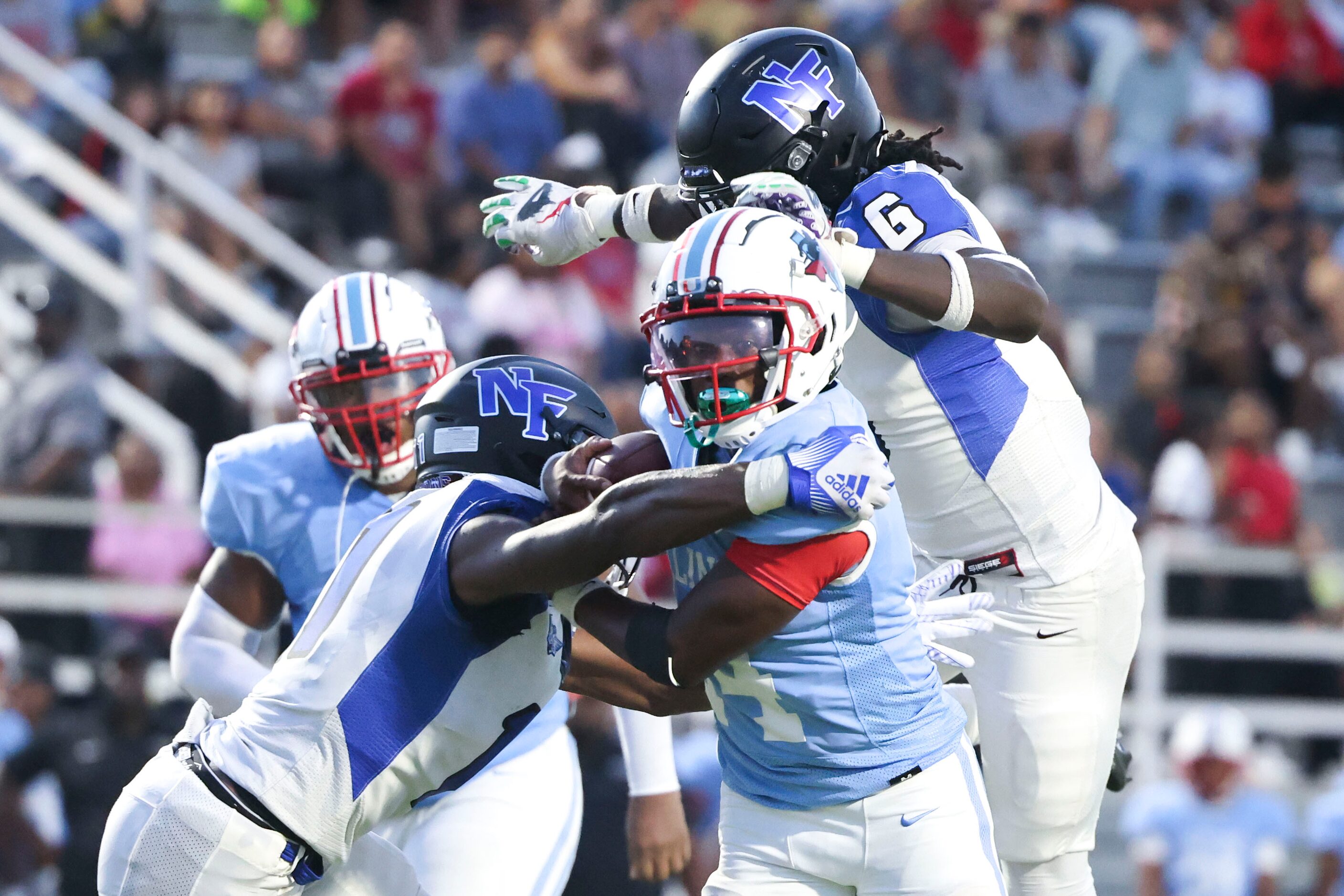 Skyline High’s quarterback Donte Ware (center) is tackled North Forney High’s J’ynv Williams...