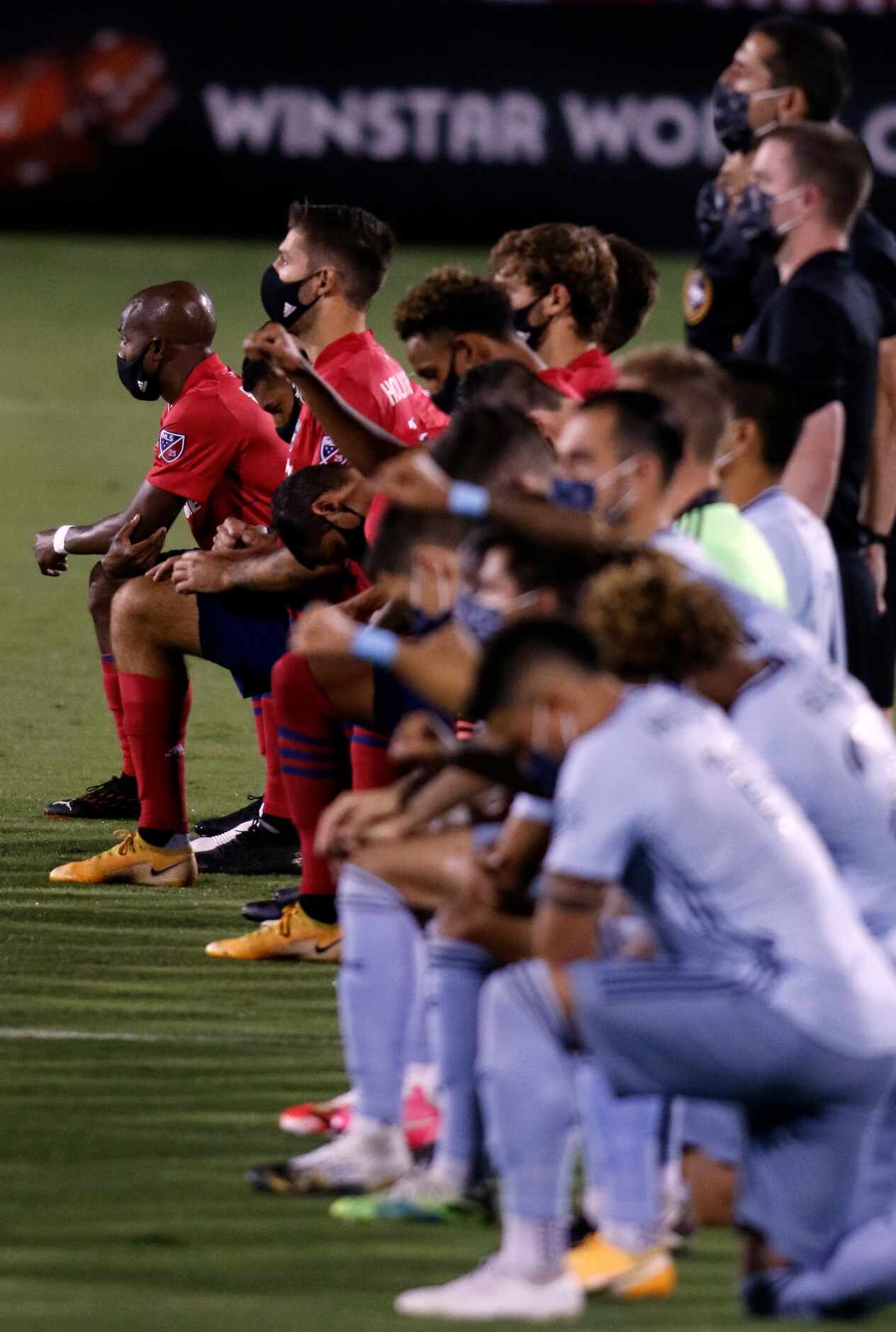 FC Dallas players (top) are joined by Sporting KC players as they all took a knee during the...