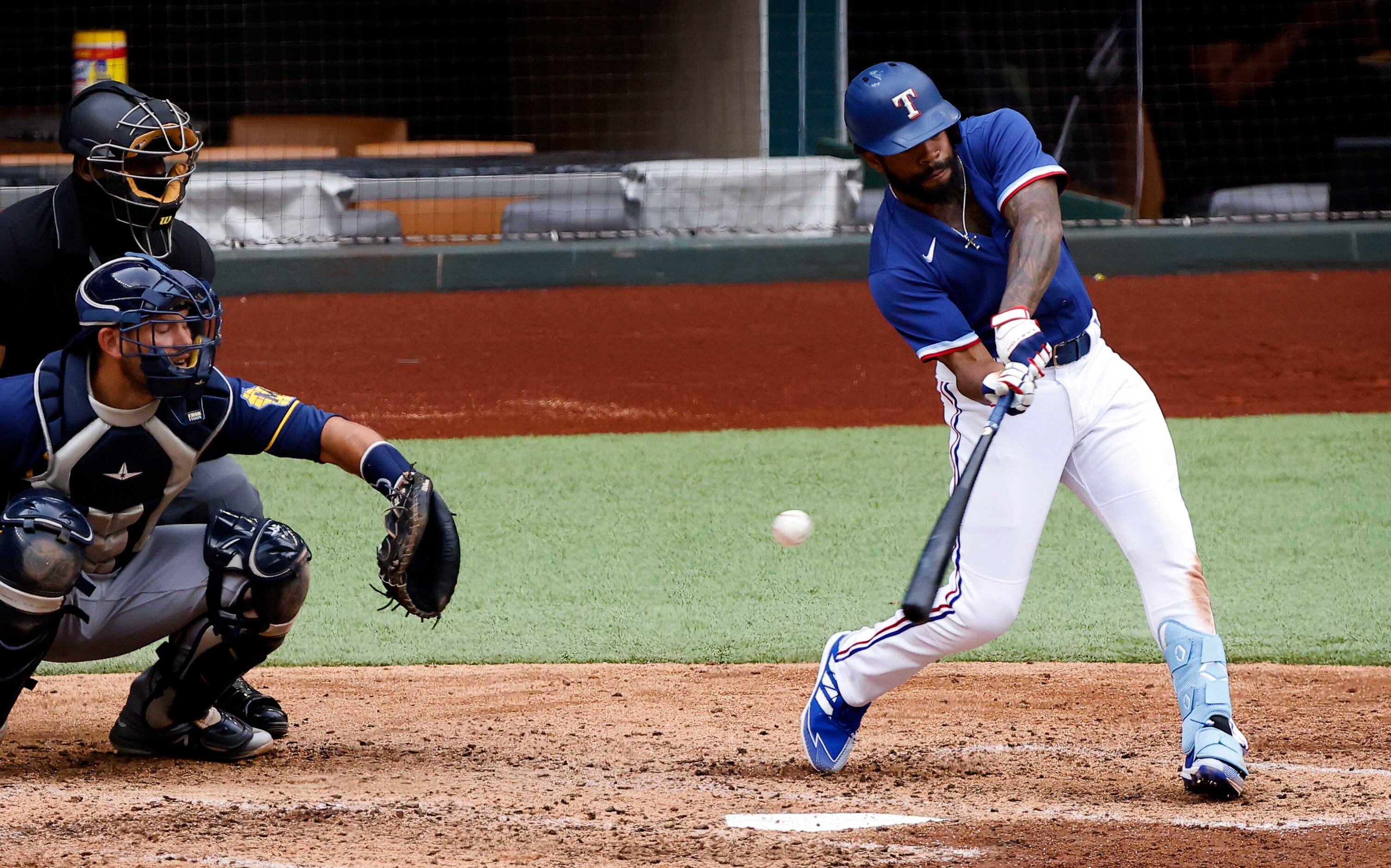 Texas Rangers batter Delino DeShields swings and misses, striking out against the Milwaukee...