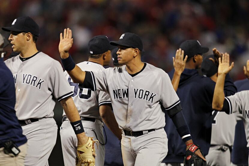 New York Yankees third baseman Alex Rodriguez and others celebrate their 7-4 over the Texas...