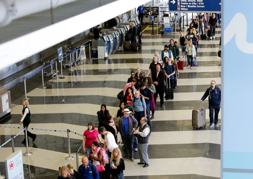  People wait in line to go through the TSA security checkpoint at Dallas Love Field in...