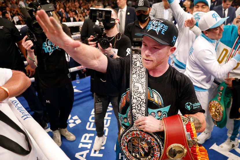 Boxers Canelo Alvarez celebrates with his belts after defeating Billy Joe Saunders in the...