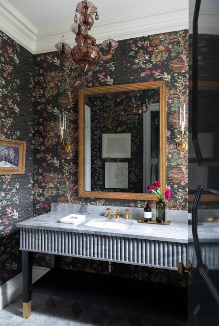 Moody powder bathroom with dark floral wallpaper, fluted marble vanity