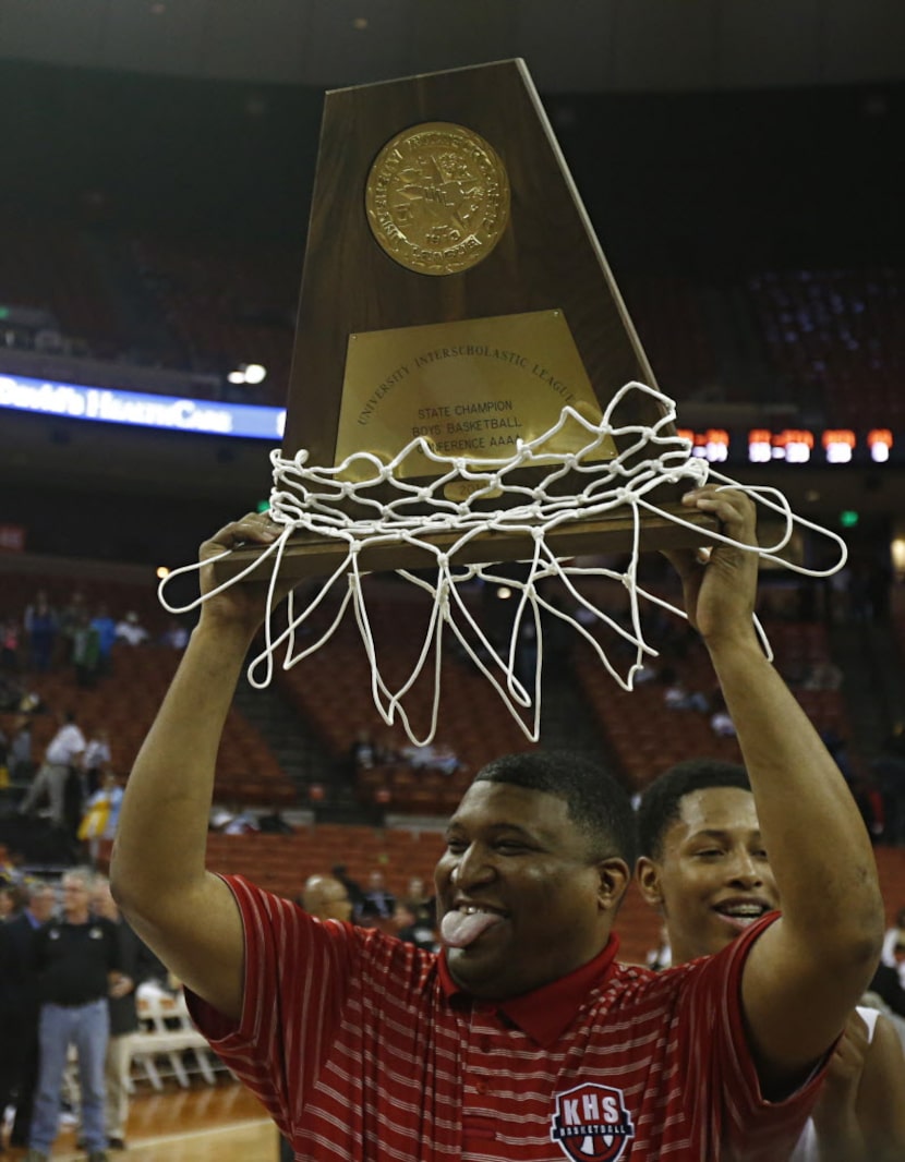 Kimball coach Royce Johnson, sticks his tongue out, as he savors holding the boys basketball...