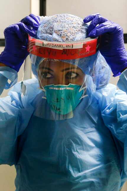 Nurse Liyu Daniel dons personal protective equipment as she prepares to enter the COVID-19...