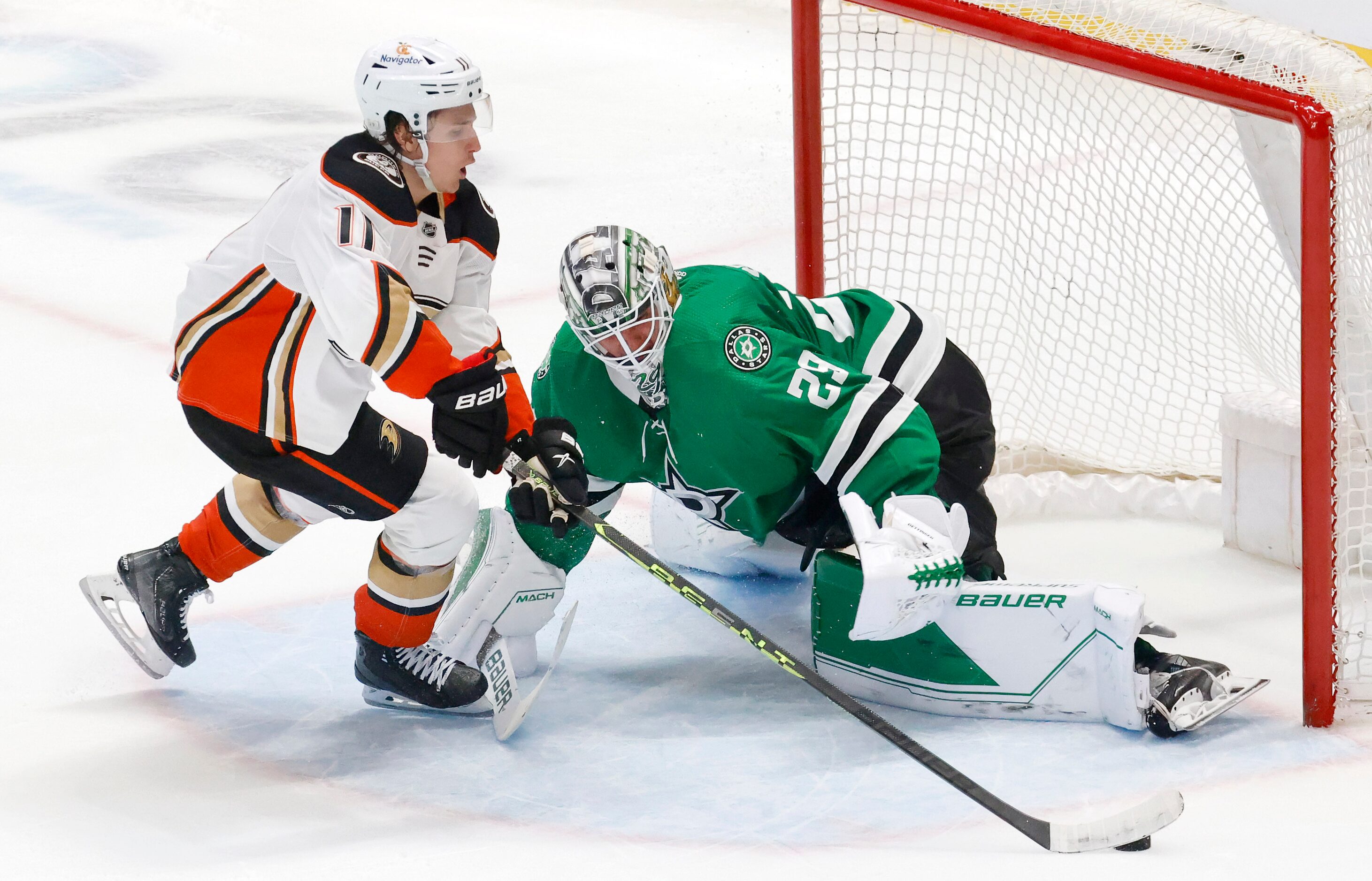 Dallas Stars goaltender Jake Oettinger (29) stops a shot by Anaheim Ducks center Trevor...