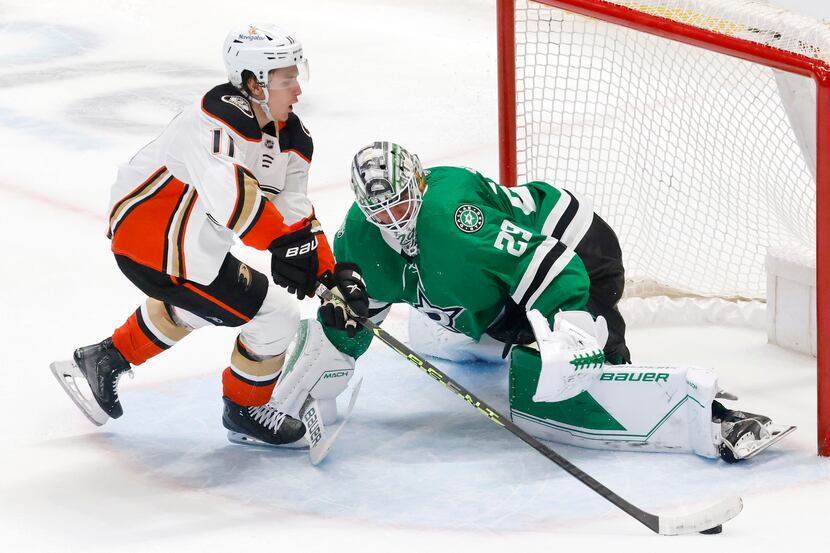 Dallas Stars goaltender Jake Oettinger (29) stops a shot by Anaheim Ducks center Trevor...