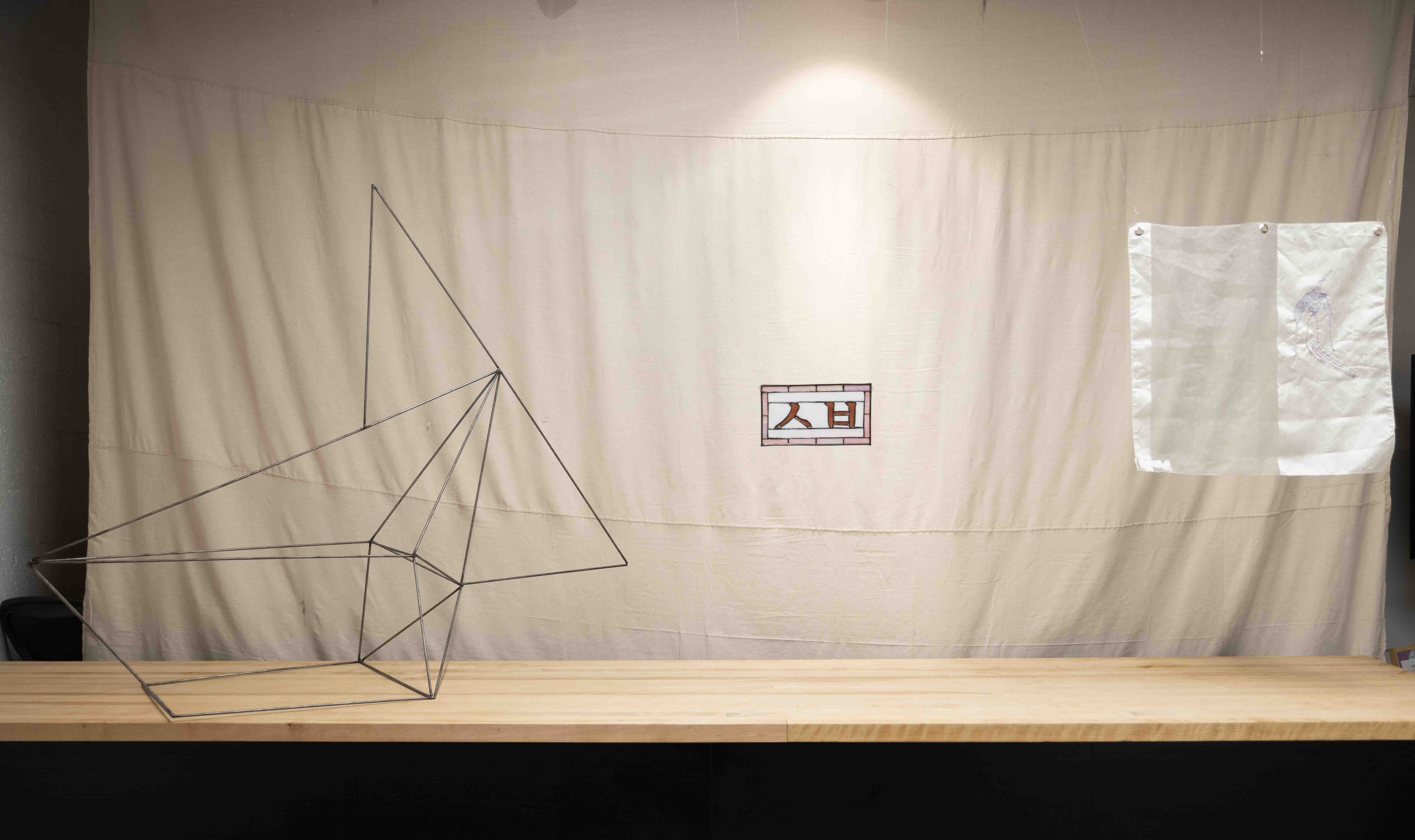 (From left) Sara Wong’s “Origami Fish,” 2014, metal, Nick Nguyen’s “Hangul in Glass,” 2024,...