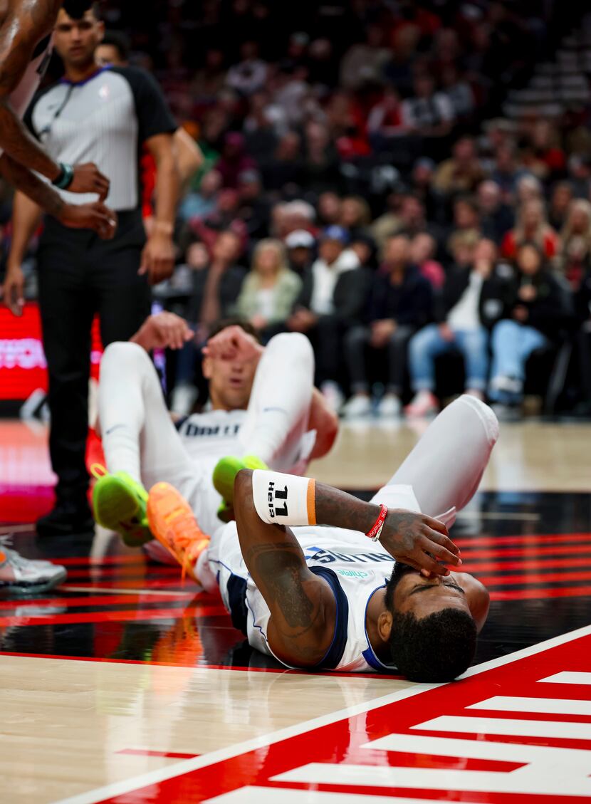 Dallas Mavericks guard Kyrie Irving lies on the court after falling during the first half of...