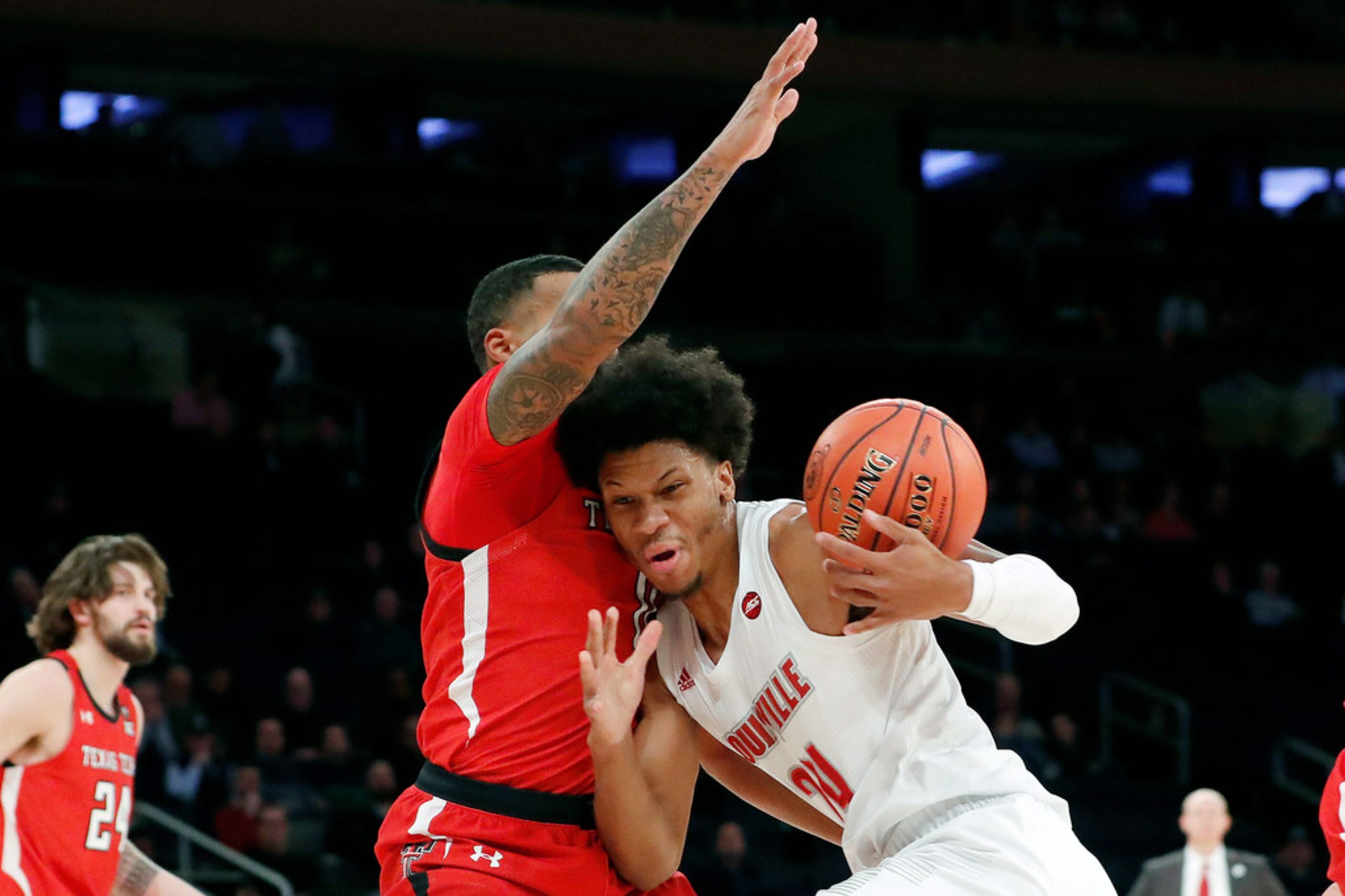 Louisville forward Dwayne Sutton, right, loses the ball as Texas Tech guard Kyler Edwards...