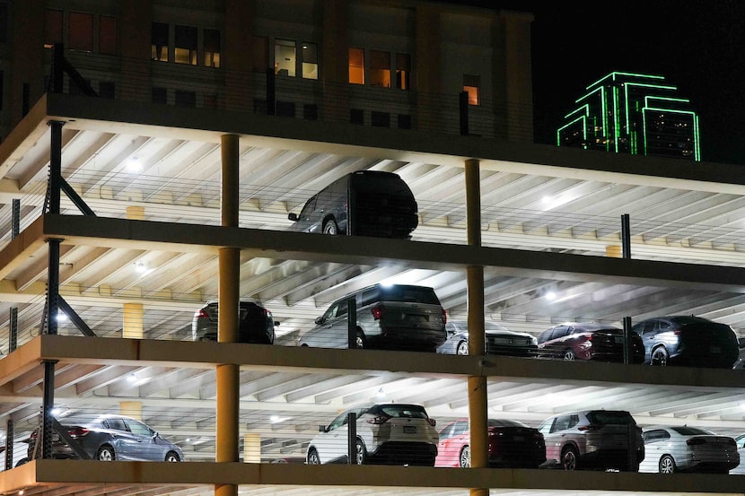 Bank of America Plaza peeks out over a parking garage on Young Street in downtown Dallas on...