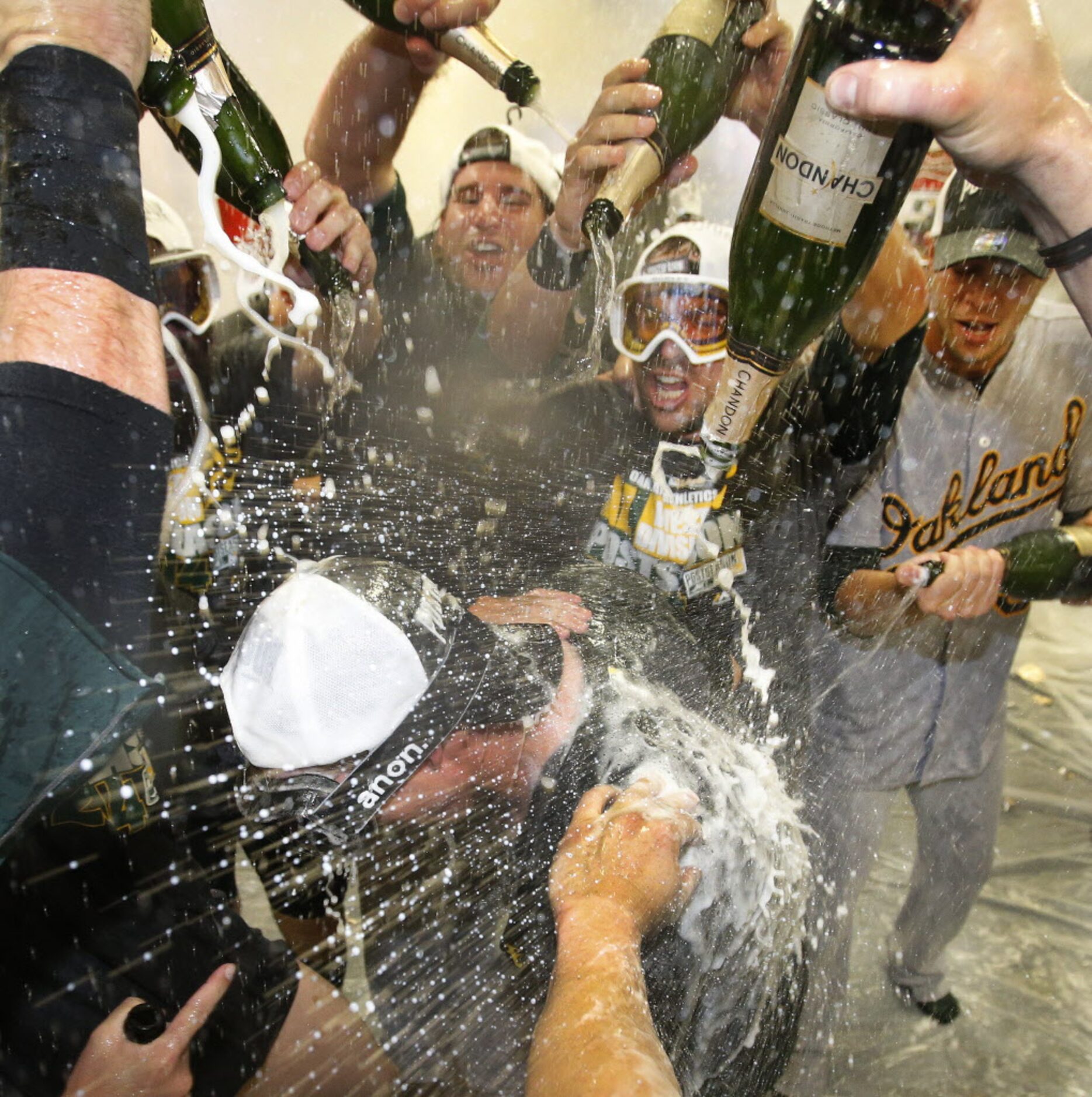 The Oakland Athletics celebrate with champagne in their locker room after clinching a wild...