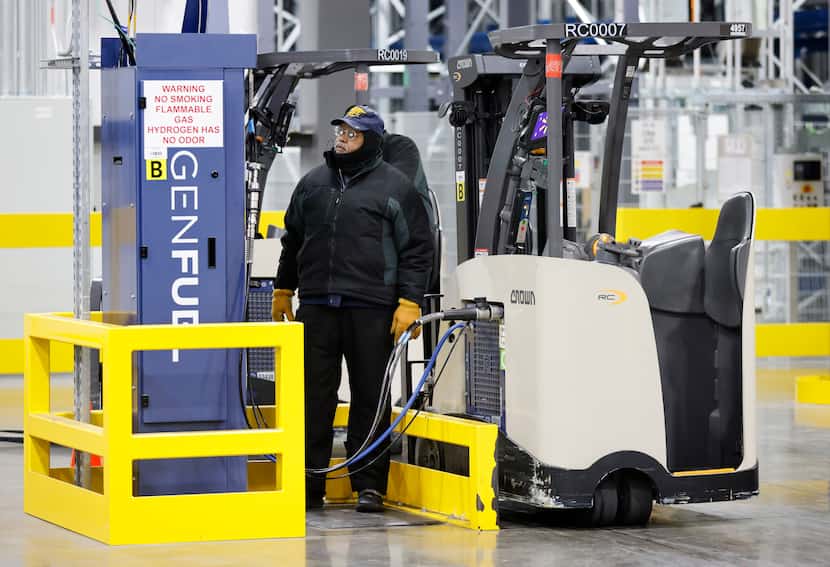 An employee fills a forklift with hydrogen at Walmart’s nearly completed,...