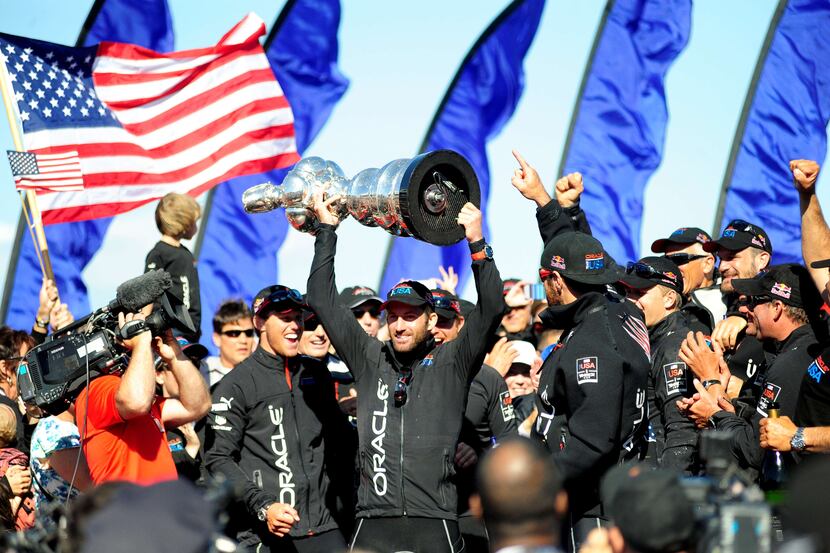 TOPSHOTS Helmsman Sir Ben Ainslie holds up the America's Cup trophy after Oracle Team USA...