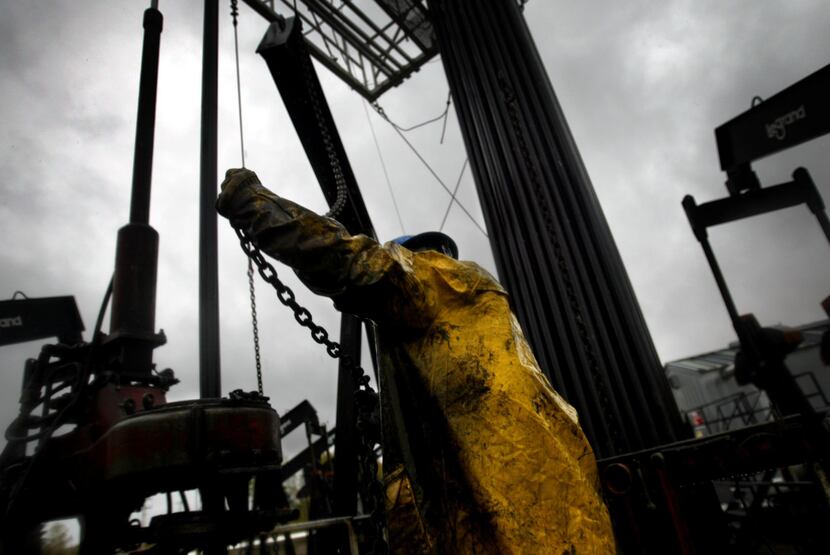 2005 FILE PHOTO -- Junior Floor Hand Mason Mack takes care of maintenance on an oil derrick...