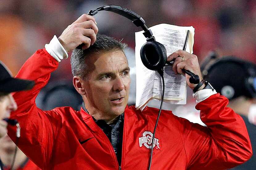 FILE - In this Dec. 31, 2016, file photo, Ohio State head coach Urban Meyer takes off his...