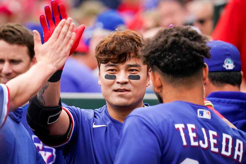 FILE - Rangers outfielder Shin-Soo Choo high fives teammates in the dugout before a spring...