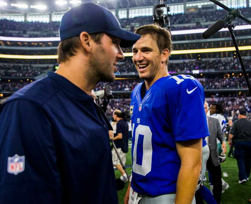 Dallas Cowboys quarterback Tony Romo (9) talks to New York Giants quarterback Eli Manning...