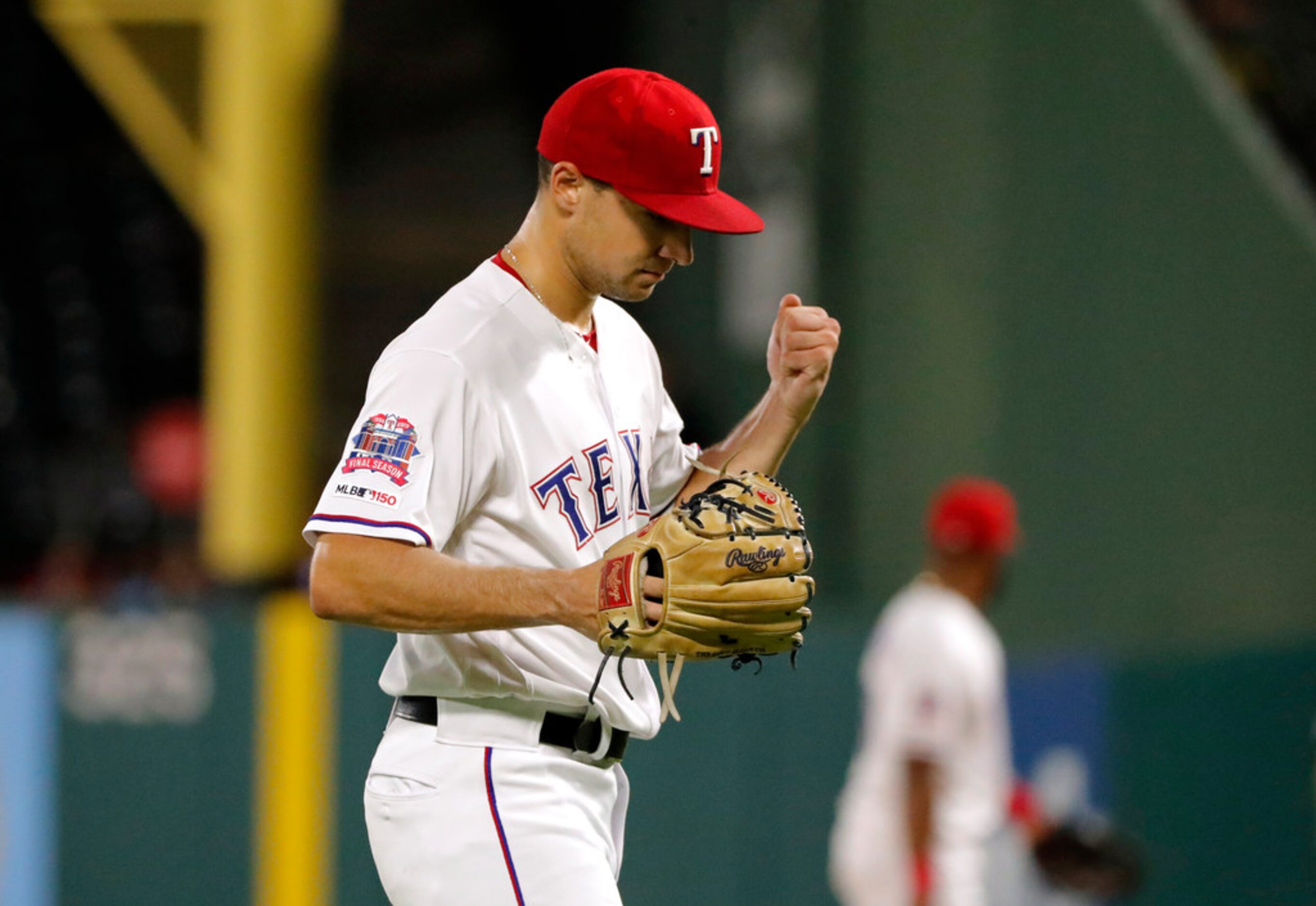 Texas Rangers starting pitcher Brock Burke pounds his glove with his fist after getting Los...