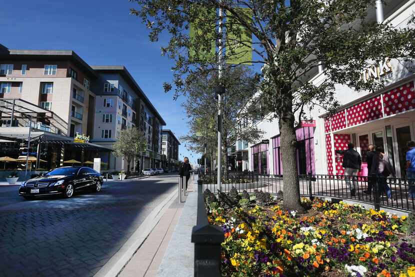 Shoppers walk down the street at Legacy West in Plano.