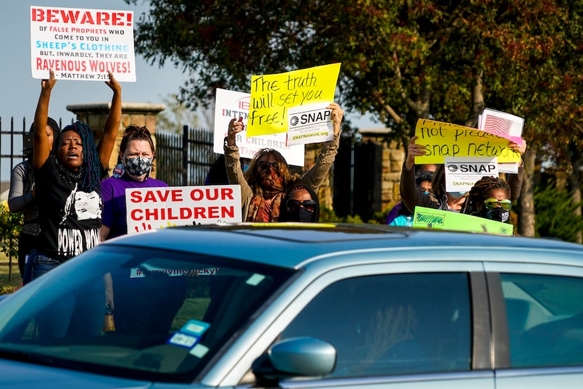 Demonstrators, including Donna Fields (left), yelled toward motorists entering the parking...