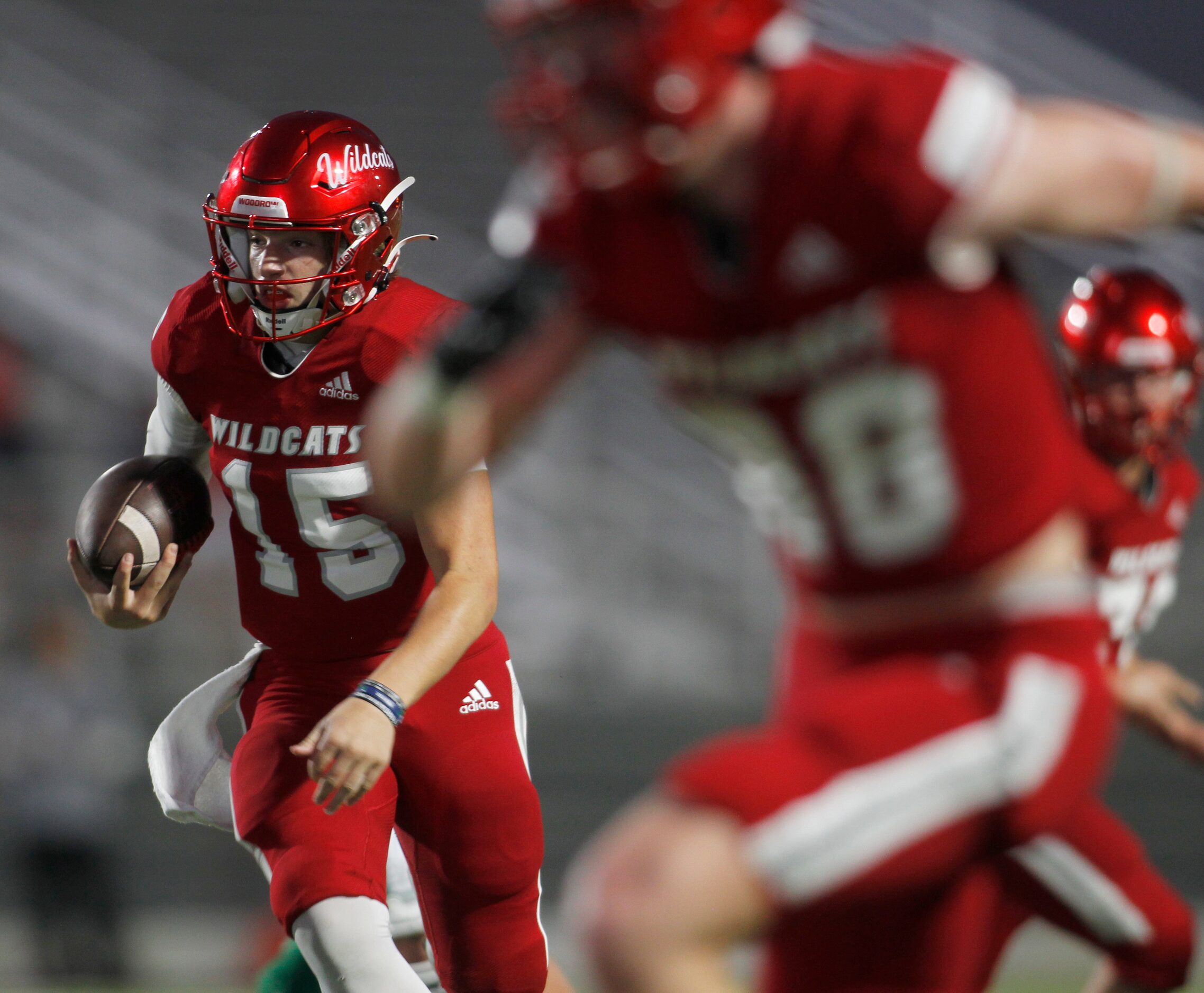 Dallas Woodrow Wilson quarterback Cam McGuire (15) follows his blockers during a first...