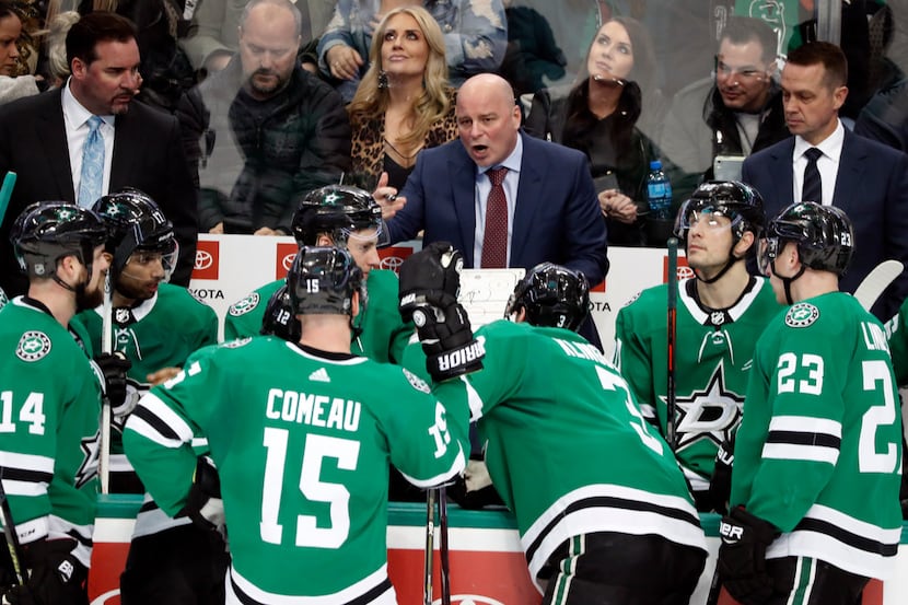 Dallas Stars head coach Jim Montgomery, center, instructs the team during a time out of an...
