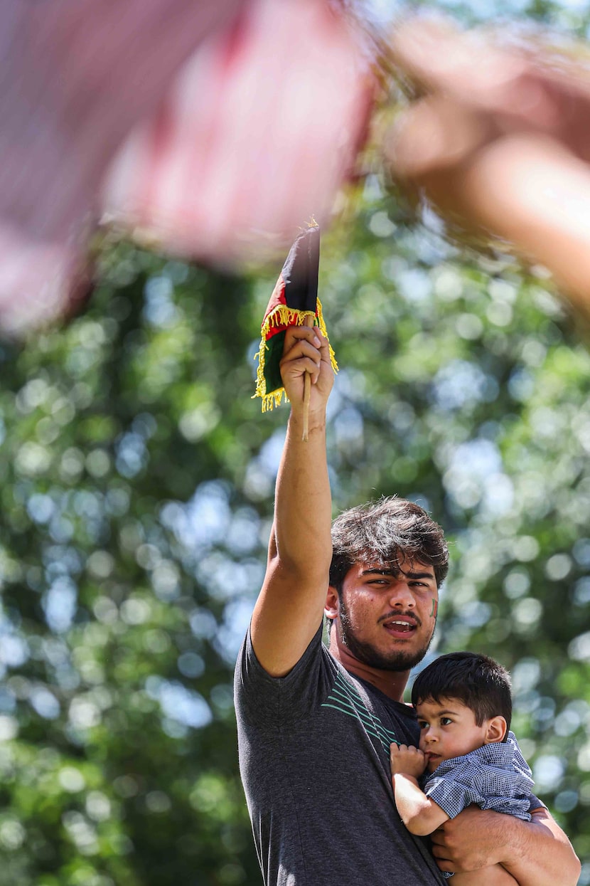 Mohammad Mahbobyar, 19, held his 1-year-old nephew Suvan Yasiney at a rally  in downtown...