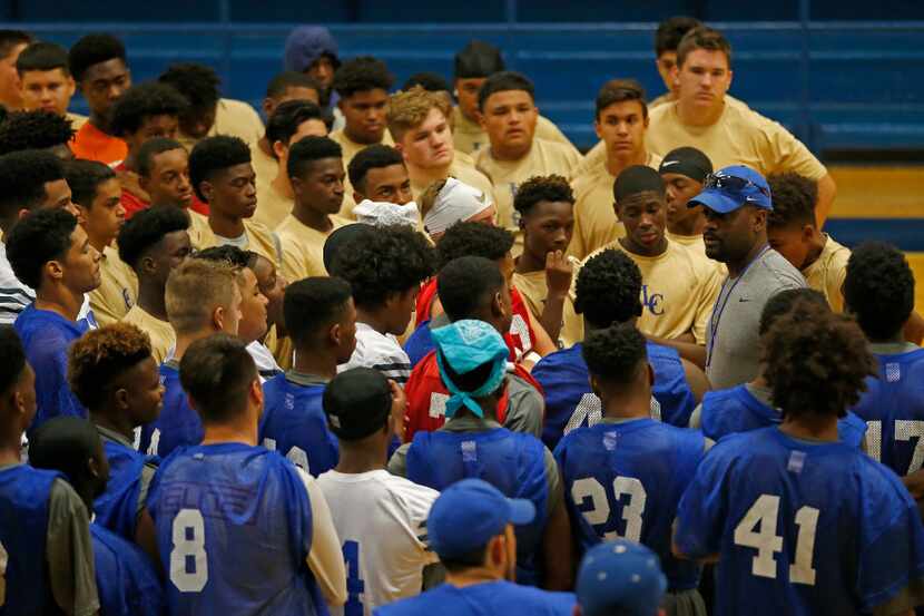 Lakeview Centennial Head Coach Kendall Miller (in a blue cap) talks with his players during...