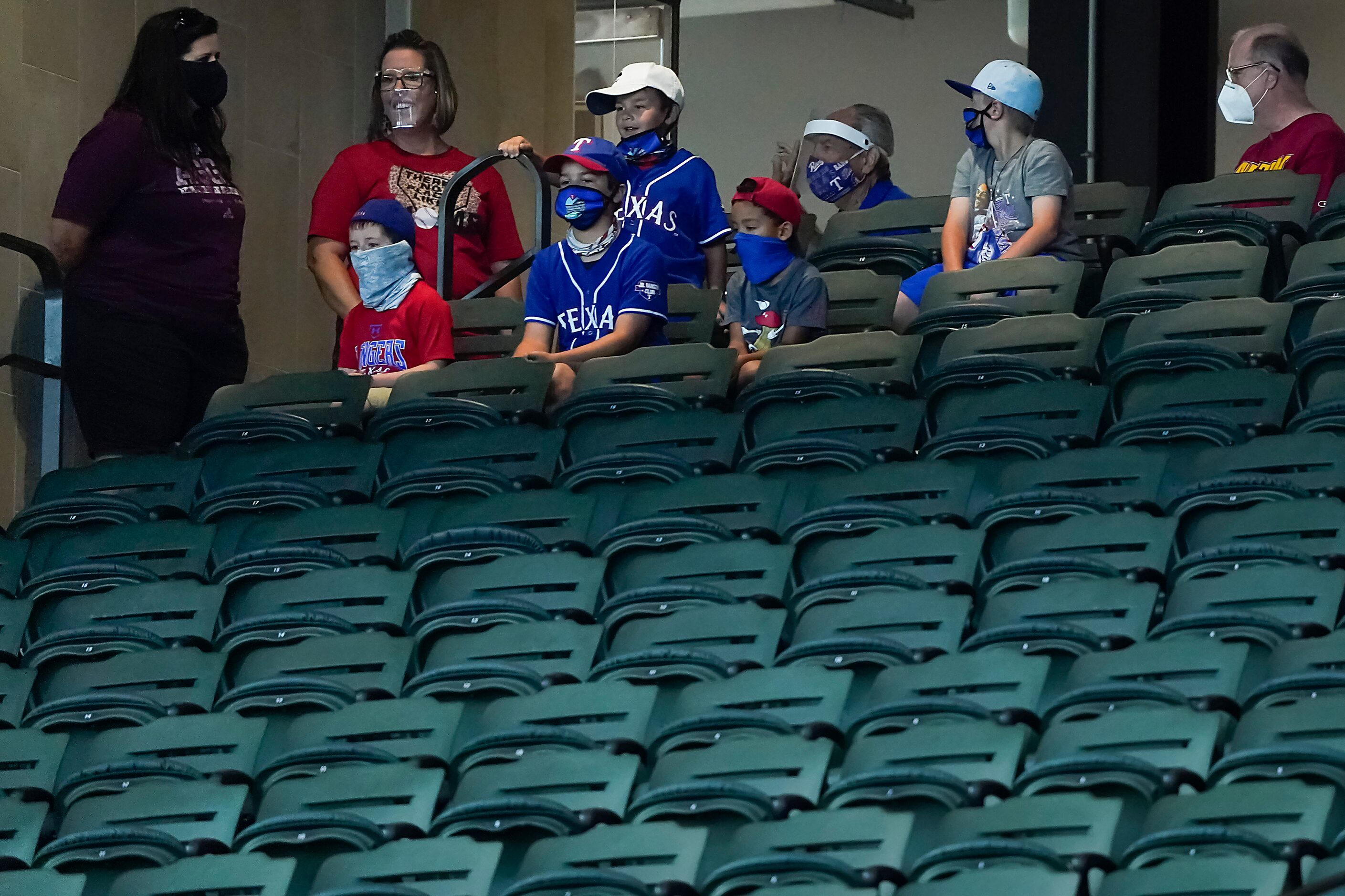 A stadium tour group pauses to watch a game between players at the Texas Rangers alternate...