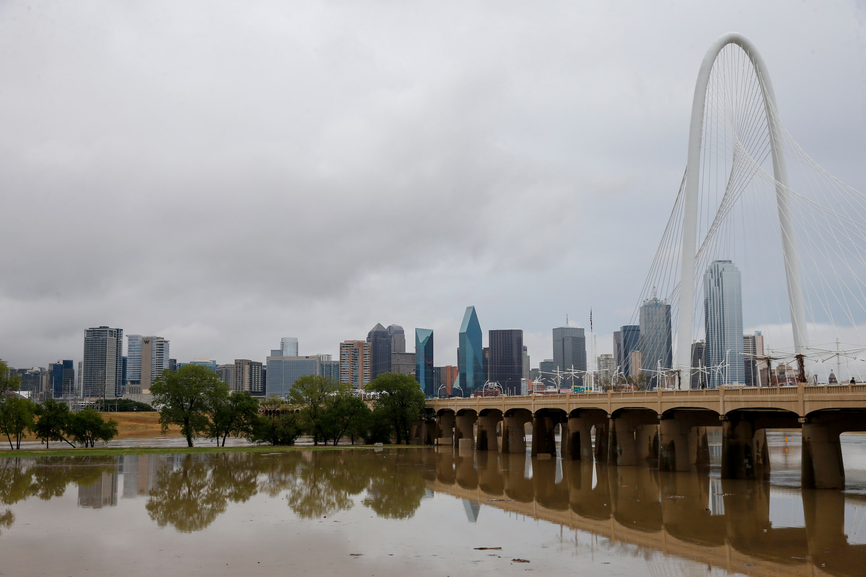 The Trinity River spreads from levee to levee near the Margaret Hunt Hill Bridge after...