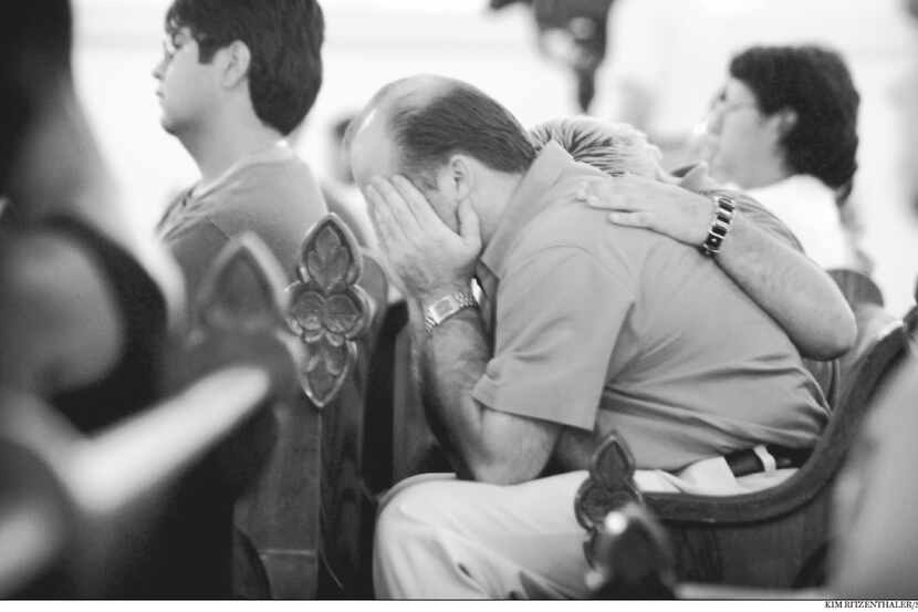 Sept. 11, 2001: Christian Pannek comforts his father, Rod Pannek, at a special Mass at the...