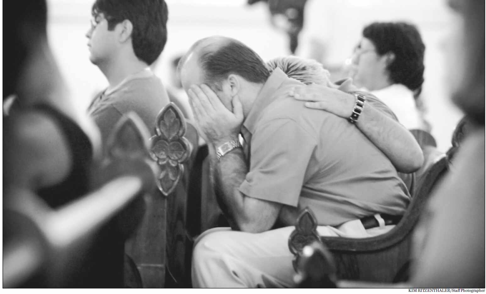 Sept. 11, 2001: Christian Pannek comforts his father, Rod Pannek, at a special Mass at the...
