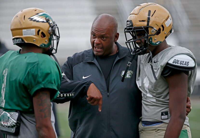 New DeSoto head coach Mike Robinson, center, talks with his players La'Vontae Shenault,...