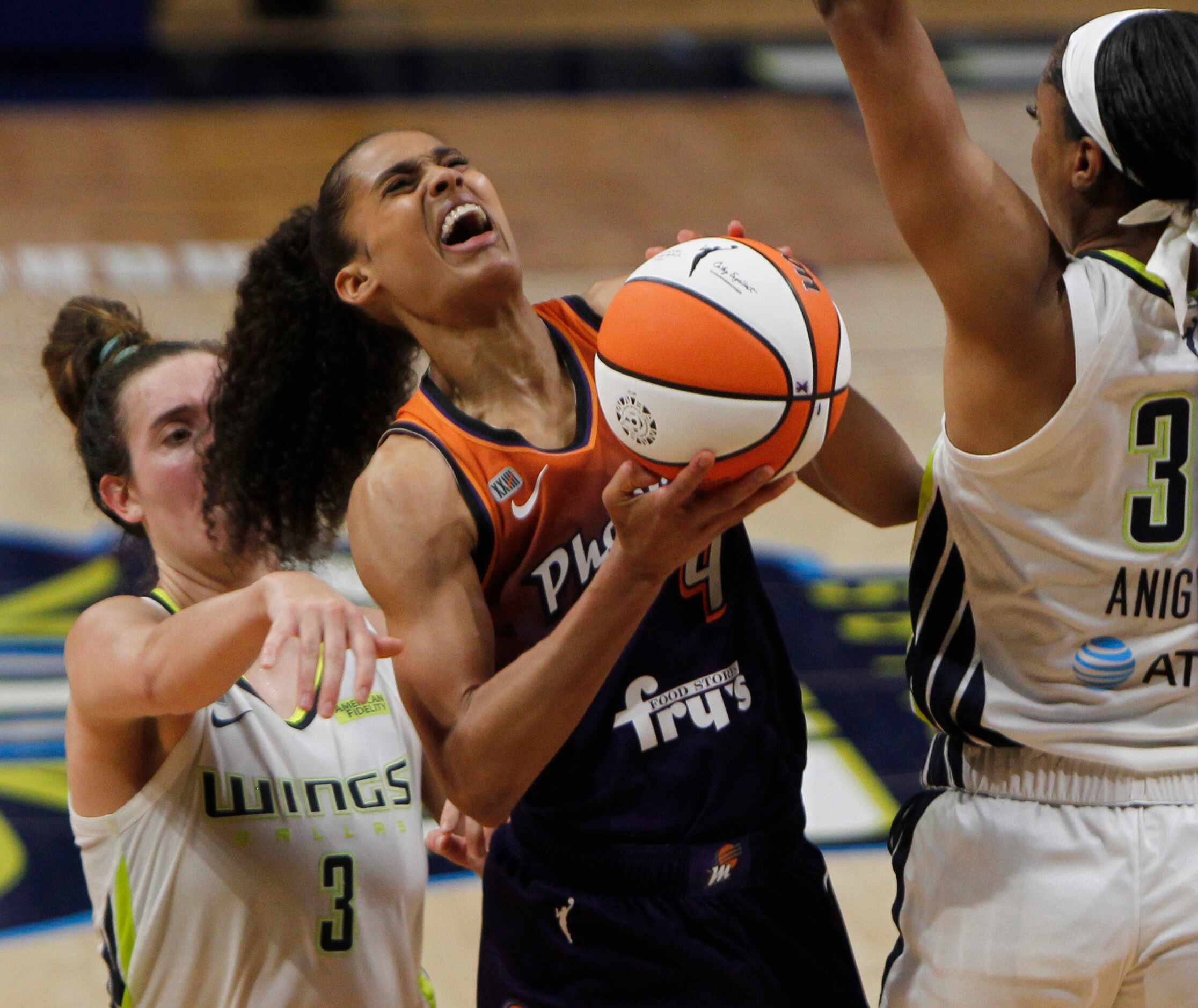Phoenix guard Skylar Diggins-Smith (4) winces as she drives amidst tight defensive coverage...