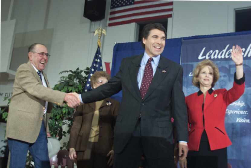 Ray Perry (left) shook his son's hand as Rick Perry, with wife Anita, announced his run for...