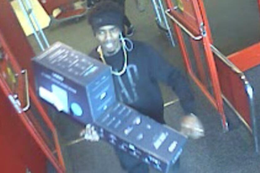 One of the suspects appears to be carrying a sound bar out of a Target store where he...