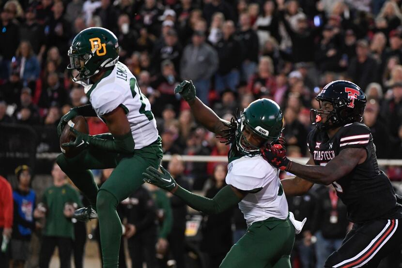 Baylor safety Devin Lemear, left, intercepts a pass intended for Texas Tech wide receiver...