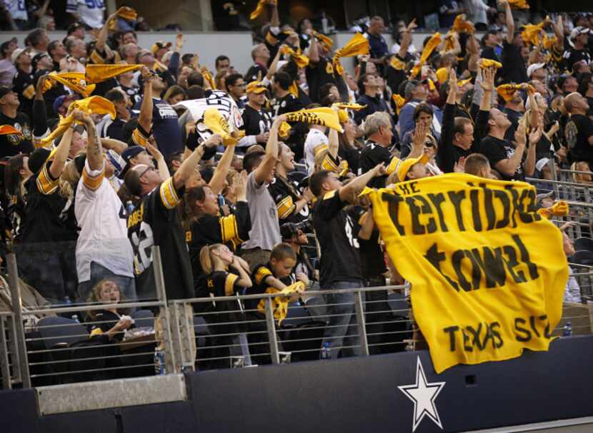 a Texas sized Terrible Towel was draped over the railing as they cheered the gold and black...